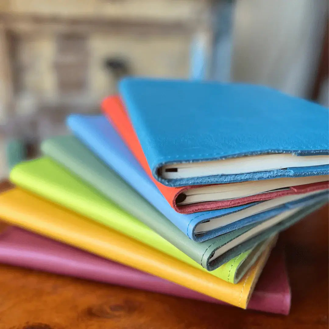 RUSTIK COLOURFUL LEATHER SLIP ON COVER + JOURNAL stacked in vibrant colors showcasing creativity and self-expression.