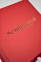 Close-up of a red gift box labeled 'Sentimental - The Art of Gifting'. Perfect for thoughtful presents.